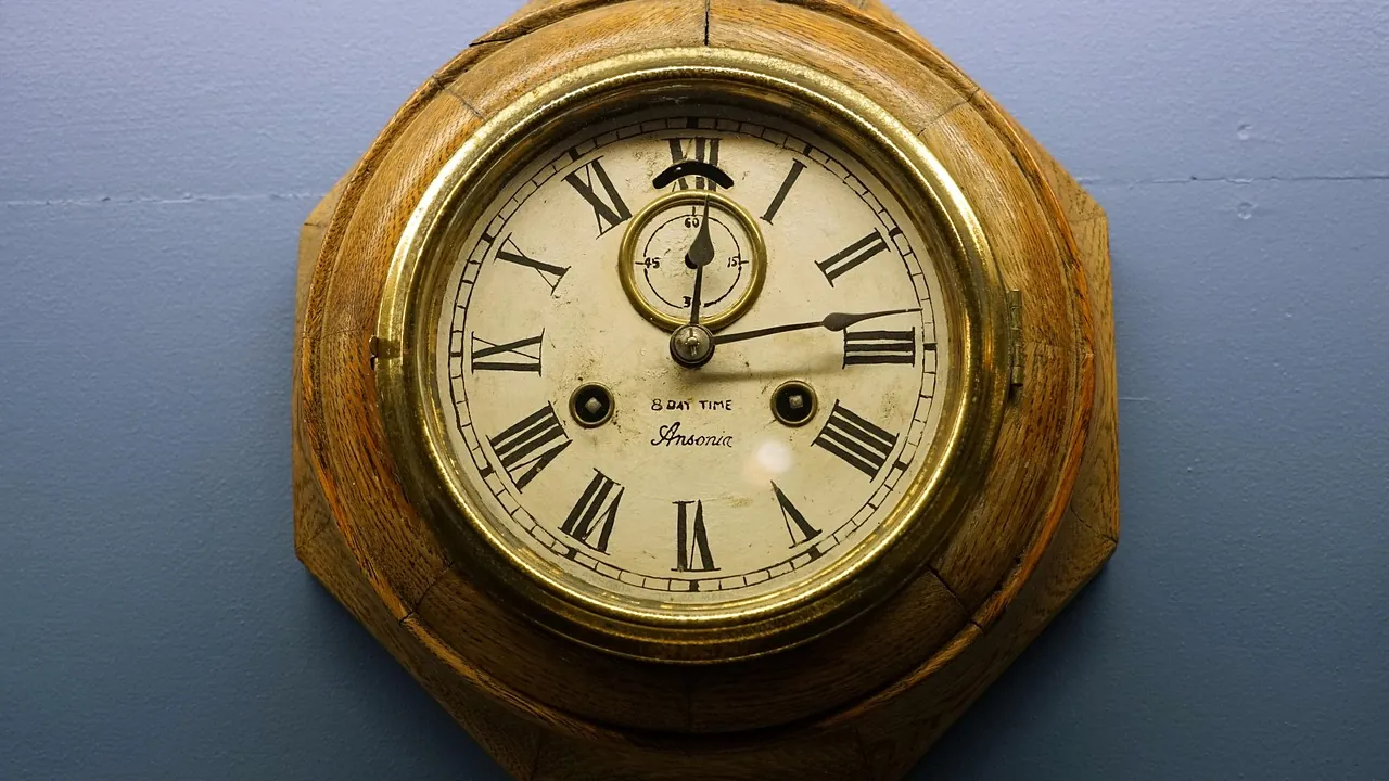 Horloge murale ancienne en laiton sur un mur bleu-gris